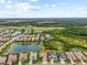 Aerial view of a home nestled within a vibrant community with a lake and green spaces at 2724 Coco Palm Cir, Wesley Chapel, FL 33543
