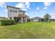 Lush backyard with covered patio, offering a serene outdoor living space for relaxing and entertaining at 2724 Coco Palm Cir, Wesley Chapel, FL 33543