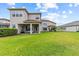 Lush green backyard with covered patio, ideal for entertaining and enjoying the outdoors at 2724 Coco Palm Cir, Wesley Chapel, FL 33543