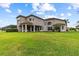 Expansive backyard featuring a spacious lawn and covered patio, perfect for outdoor enjoyment at 2724 Coco Palm Cir, Wesley Chapel, FL 33543