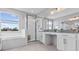 Bright bathroom featuring a soaking tub, walk-in shower, dual sinks, and granite countertops at 2724 Coco Palm Cir, Wesley Chapel, FL 33543