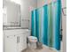 Bathroom with a white vanity, granite countertop, and a tub with a blue and green shower curtain at 2724 Coco Palm Cir, Wesley Chapel, FL 33543