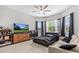 Modern bedroom with a TV and large windows with blinds at 2724 Coco Palm Cir, Wesley Chapel, FL 33543