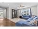 Comfortable bonus room featuring a stylish blue sectional sofa, ceiling fan and large bookcase at 2724 Coco Palm Cir, Wesley Chapel, FL 33543