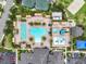 Aerial view of community pools, tennis courts, and lounge areas surrounded by palm trees at 2724 Coco Palm Cir, Wesley Chapel, FL 33543