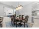 A dining room adjacent to kitchen and living room features a chandelier and dark wood table in an open-concept space at 2724 Coco Palm Cir, Wesley Chapel, FL 33543