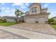 Charming two-story home featuring a three-car garage, paver driveway, and professionally landscaped front yard at 2724 Coco Palm Cir, Wesley Chapel, FL 33543