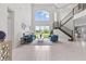 Bright living room with soaring ceilings, large windows, modern furniture, and staircase views at 2724 Coco Palm Cir, Wesley Chapel, FL 33543