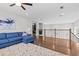 Upstairs loft living area with hardwood floors and cozy blue sectional sofa at 2724 Coco Palm Cir, Wesley Chapel, FL 33543
