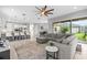 Spacious living room featuring a ceiling fan, breakfast bar, and view to backyard at 2724 Coco Palm Cir, Wesley Chapel, FL 33543