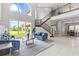 Bright, open living room with high ceilings, large windows, and staircase at 2724 Coco Palm Cir, Wesley Chapel, FL 33543