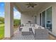 Inviting covered patio with comfortable seating, ceiling fan, and view of lush landscaping at 2724 Coco Palm Cir, Wesley Chapel, FL 33543