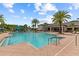Resort-style pool area with palm trees, lounge chairs, and a clubhouse in a Primary-planned community at 2724 Coco Palm Cir, Wesley Chapel, FL 33543