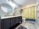 Beautiful bathroom with dual sinks, modern lighting, and vibrant shower curtain at 3005 Wilton Ln, Valrico, FL 33596