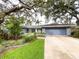 Inviting single-story home with lush landscaping, mature trees, and a spacious driveway leading to a two-car garage at 3005 Wilton Ln, Valrico, FL 33596