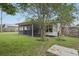 View of the backyard featuring a screened patio with hot tub and privacy fence at 3121 Egret Ter, Safety Harbor, FL 34695
