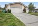 View of a home's driveway and two-car garage showing some yard and plantings at 3121 Egret Ter, Safety Harbor, FL 34695