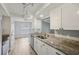 Bright kitchen features granite countertops, stainless appliances, white cabinetry, and modern lighting, offering a delightful cooking space at 3121 Egret Ter, Safety Harbor, FL 34695