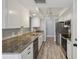Modern kitchen featuring stainless steel appliances, granite countertops, and white cabinets, providing a clean and efficient cooking space at 3121 Egret Ter, Safety Harbor, FL 34695