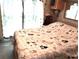 Bedroom with a neutral quilt covered in cats and a sheer curtain-covered window at 35152 Dodie, Zephyrhills, FL 33541
