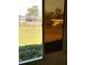 View of backyard through a sliding glass door, showing a large lawn and mature trees at 39343/39349 Rusbe, Zephyrhills, FL 33540