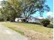 Charming home with mature trees, flowering bushes, and a two-car garage at 39343/39349 Rusbe, Zephyrhills, FL 33540
