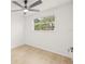 Well-lit bedroom with fan and large window showing mature trees and landscaping at 4220 E Regnas Ave, Tampa, FL 33617