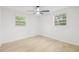 Bright bedroom with light wood floors, ceiling fan, and windows providing natural light at 4220 E Regnas Ave, Tampa, FL 33617