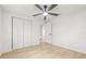 Bedroom with wood floors, ceiling fan, closet, and a white door with entry to hallway at 4220 E Regnas Ave, Tampa, FL 33617