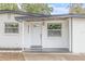 Home exterior featuring the front door and well kept landscape at 4220 E Regnas Ave, Tampa, FL 33617
