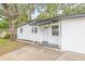 Charming single-story home featuring a white exterior, modern black trim, and a well-manicured front yard at 4220 E Regnas Ave, Tampa, FL 33617