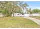 House's front exterior with a well-manicured lawn and mature trees at 4220 E Regnas Ave, Tampa, FL 33617