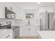 Updated kitchen featuring stainless steel appliances, white cabinets, and modern hardware at 4220 E Regnas Ave, Tampa, FL 33617