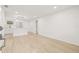 Bright living room with new wood floors open to the eat-in kitchen featuring modern lighting at 4220 E Regnas Ave, Tampa, FL 33617