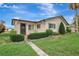 Inviting front exterior featuring a well-manicured lawn, decorative shrubs, and a paved walkway at 4512 Superior Ln, Clearwater, FL 33762