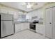 Bright kitchen with stainless steel appliances, white cabinets, granite countertops, and white tile flooring at 4512 Superior Ln, Clearwater, FL 33762
