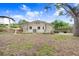 Rear view of home with a large backyard, offering privacy and space for outdoor activities and relaxation at 4640 W Lamb Ave, Tampa, FL 33629