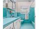 Turquoise tiled bathroom with vintage design, includes a sink, toilet, and shower/tub combo at 4640 W Lamb Ave, Tampa, FL 33629