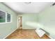 Bright, empty bedroom with hardwood floors, large windows, and pale green walls at 4640 W Lamb Ave, Tampa, FL 33629
