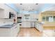 Well-lit kitchen featuring white cabinetry, stainless steel appliances, and tile flooring at 4640 W Lamb Ave, Tampa, FL 33629