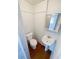 Small bathroom with toilet, sink, mirror, and wooden-look floors at 4722 Harris Ave, Sarasota, FL 34233