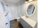 Bright bathroom featuring new shower, vanity, and wood-look tile flooring at 4722 Harris Ave, Sarasota, FL 34233