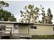 Ranch style home featuring a wooden deck and neutral siding, surrounded by mature trees at 4722 Harris Ave, Sarasota, FL 34233