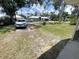 Lawn of a home with well-maintained landscaping, driveway, and a parked car on a sunny day at 4722 Harris Ave, Sarasota, FL 34233