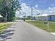 Residential street with well-maintained homes, landscaping, and overhead utility lines on a sunny day at 4722 Harris Ave, Sarasota, FL 34233