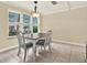 Bright dining area featuring tile floors, a wood table, four chairs, and a window with natural light at 5501 80Th N St # 206, St Petersburg, FL 33709