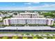 Aerial view of a condominium building with a parking area surrounded by lush landscaping at 5501 80Th N St # 206, St Petersburg, FL 33709