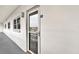 Exterior entrance featuring door 206 on a white wall with light fixture and windows at 5501 80Th N St # 206, St Petersburg, FL 33709