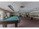 Spacious game room featuring multiple billiard tables, ceiling fans, and carpeted flooring at 5501 80Th N St # 206, St Petersburg, FL 33709