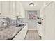 The kitchen features white cabinets, gray countertops, backsplash, and appliances at 5501 80Th N St # 206, St Petersburg, FL 33709